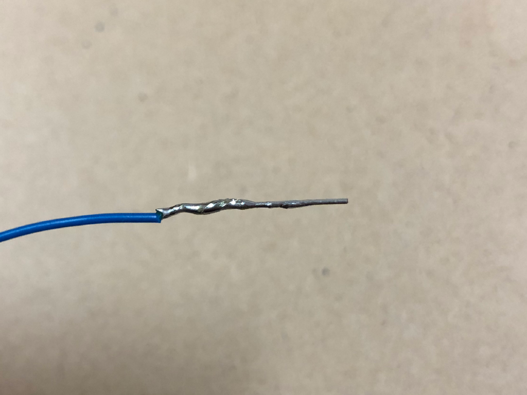 電線の心線と鈴メッキ線の接合部をはんだ付けしている様子